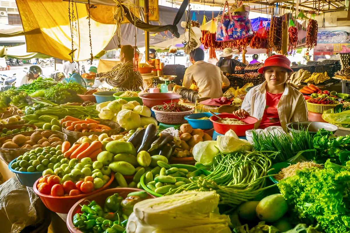 Colourful fresh produce at Kampot's local market where budget travelers can purchase authentic Cambodian ingredients for $1-3, significantly cheaper than tourist areas in neighbouring countries